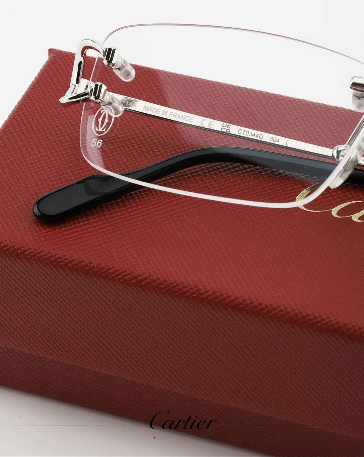 City Specs 2026 Top profile view of Cartier CT0344O 004 silver rimless glasses resting on red box at City Specs Manchester and Sheffield
